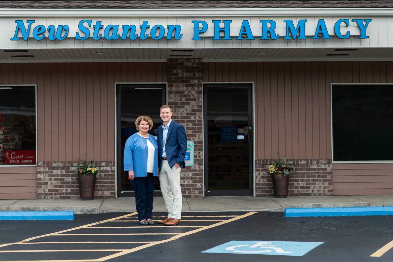 Pharmacists and owners Julie Lewandowski and Shane Daugherty standing together outside New Stanton Pharmacy