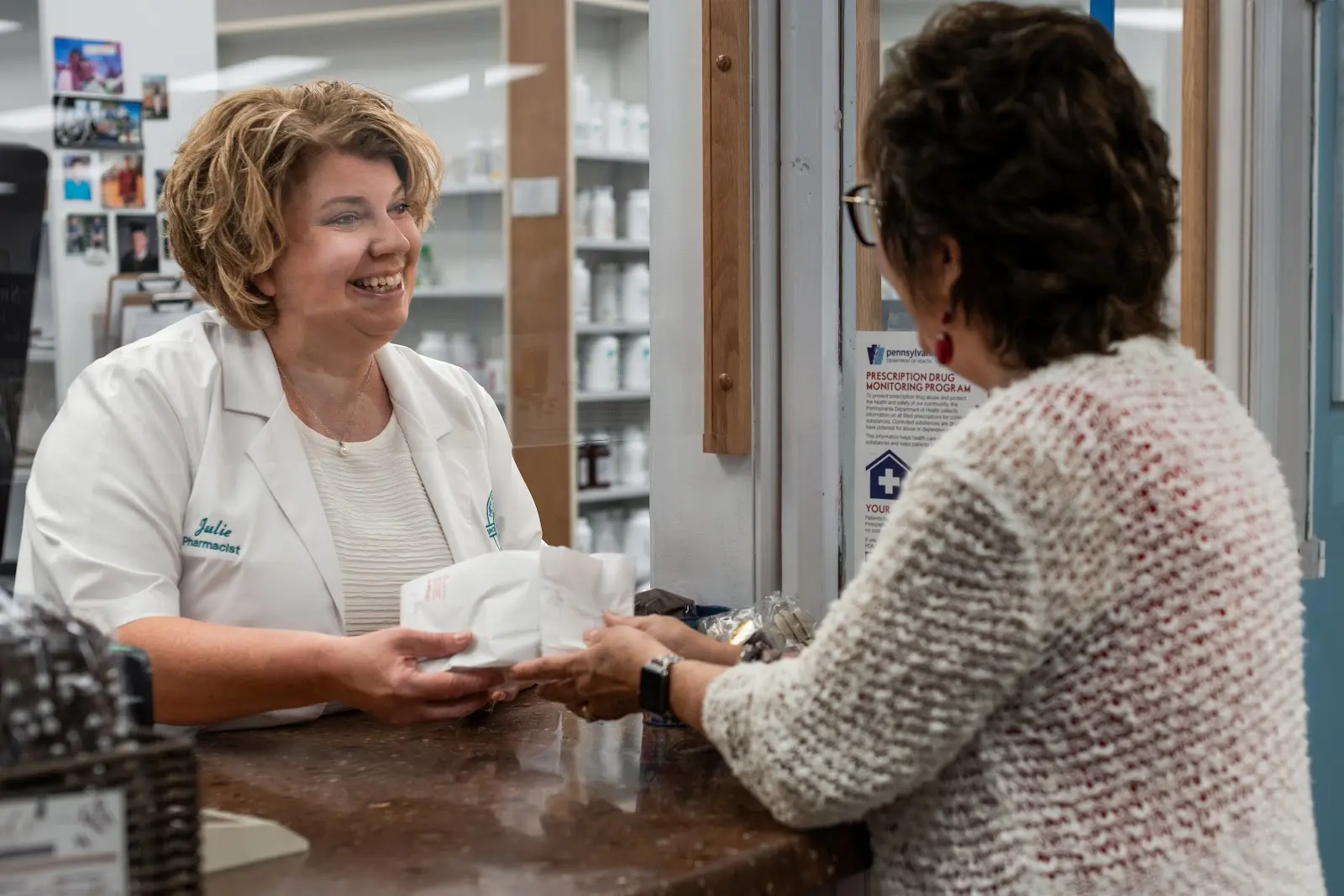 A New Stanton pharmacist smiling as she helps a customer at the counter